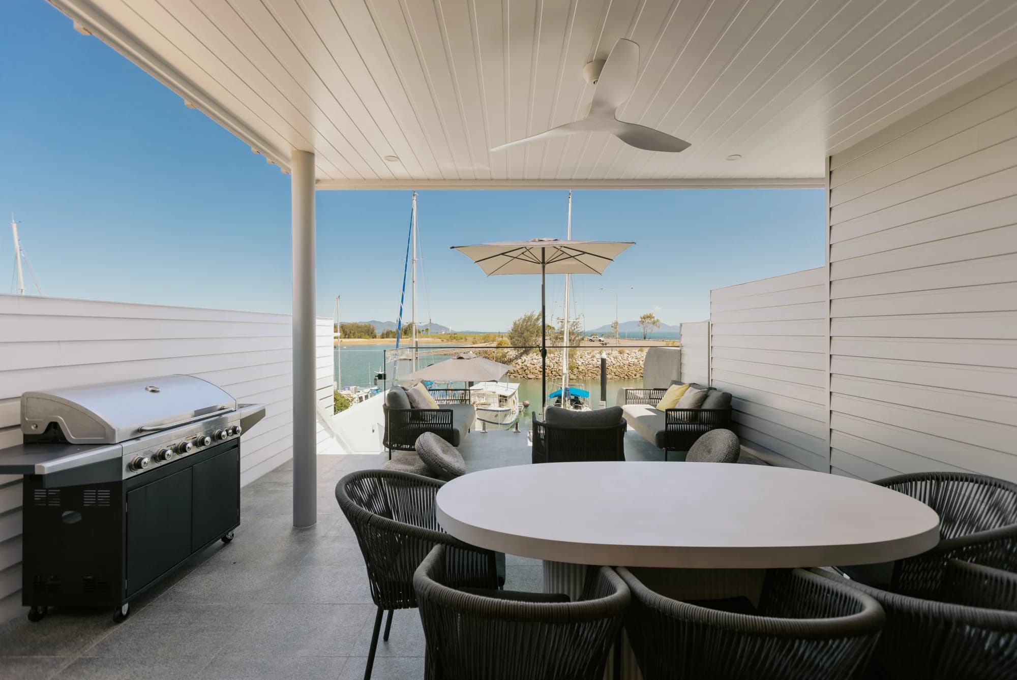 Covered dining terrace overlooking the water at Lavish